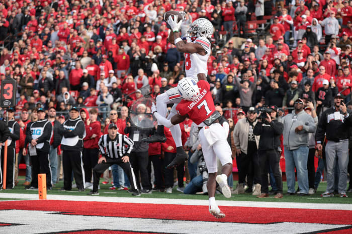 Marvin Harrison Jr. jumps up to catch the ball in the endzone while another player reaches up to try to pull him down